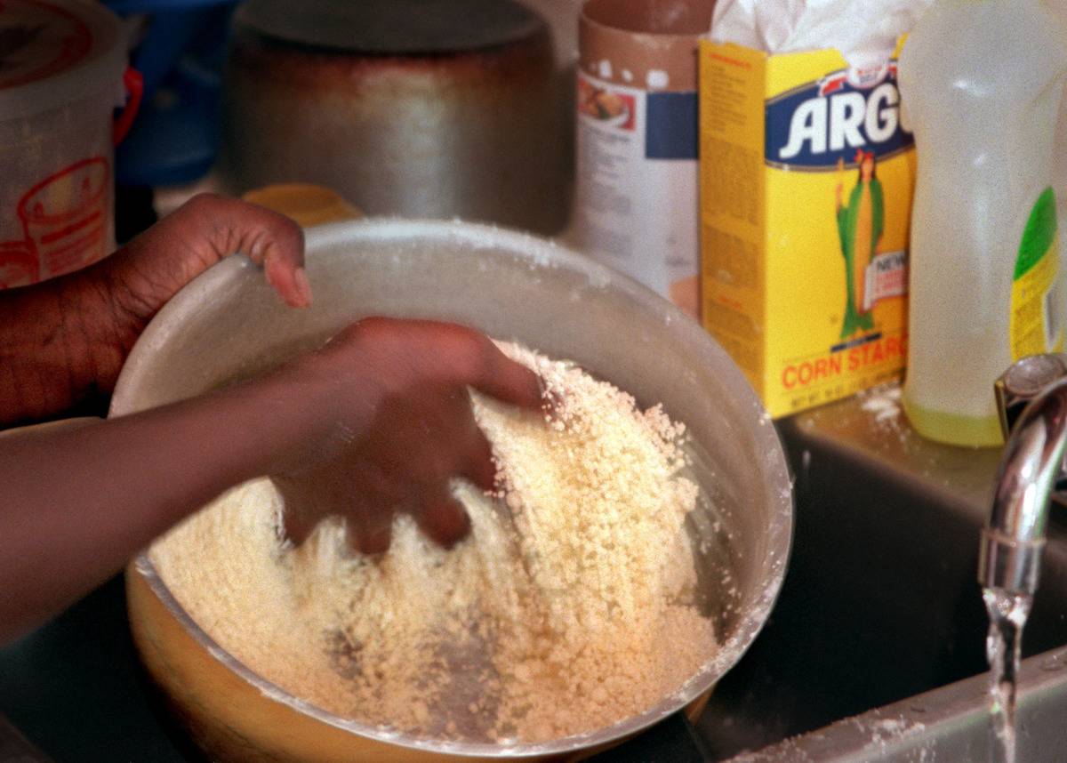Un homme mélange de la fécule de maïs dans un bol.
